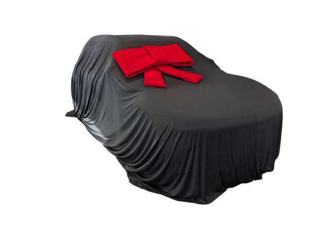 istock Black covered car with a red bow in front of a white background 2159159363