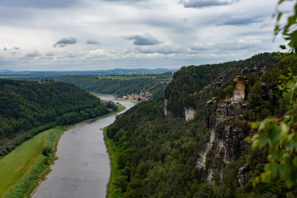 istock A river flows through a lush green valley with a rocky cliff in the background 2159159470