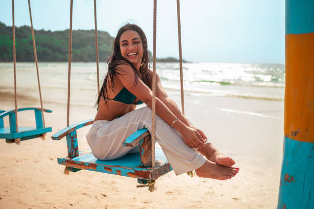 istock Joyful Hispanic Woman Enjoying Swing at Seaside 2159160344