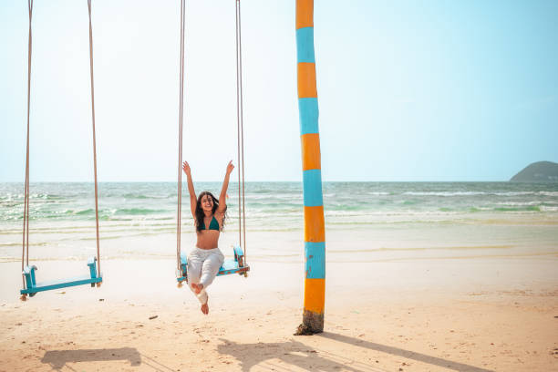 istock Hispanic Woman Enjoying Swing on Sandy Beach 2159160354