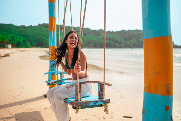 istock Joyful Hispanic Woman on Beach Swing 2159160355