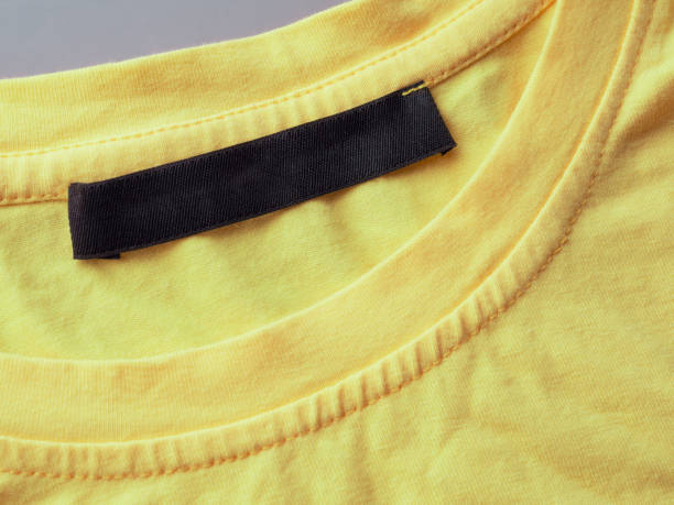 istock Yellow t-shirt with blank label logo tag close-up 2159162773
