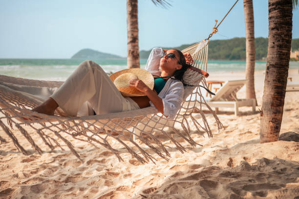 istock Relaxed Hispanic Woman Enjoying Beach Hammock Time 2159165110