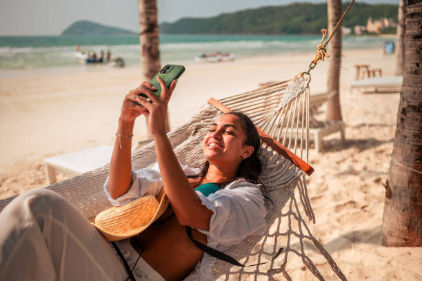 istock Hispanic Woman Relaxing on Beach with Selfie 2159165127