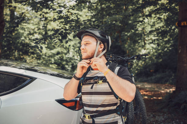 istock Mountain biker securing his helmet near his electric car 2159168864
