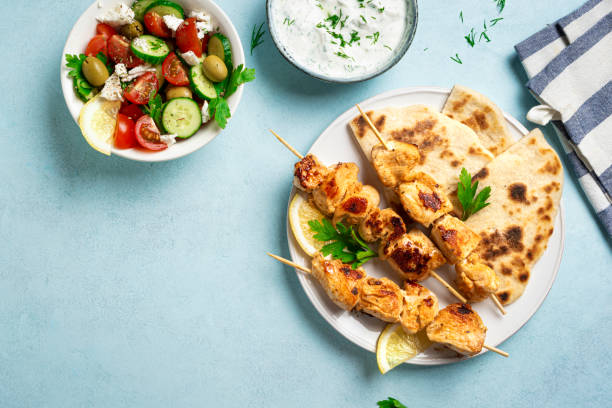 istock Chicken souvlaki kebabs and greek salad 2159168911