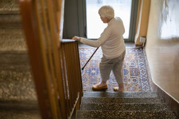 istock Elderly woman walking down the stairs 2159172210