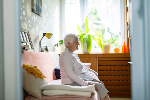 istock Elderly woman sitting alone on a bed in nursing home 2159172270