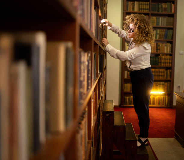 a young student is in the school library and chooses books