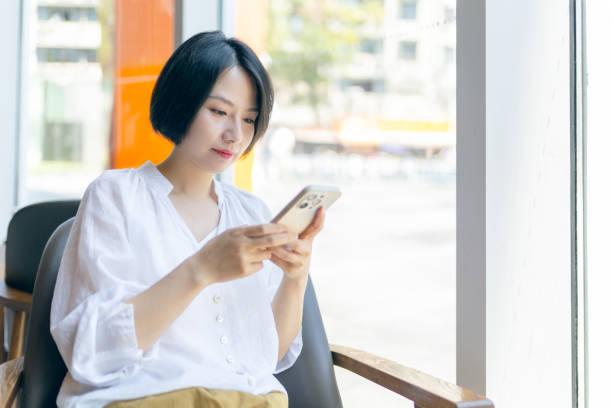 istock Young woman  using mobile phone in cafe 2159173277