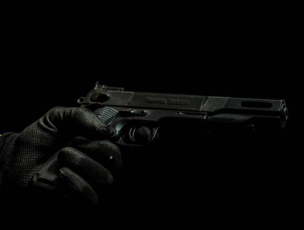 istock A black gun is being held by a person in a black glove 2159174702