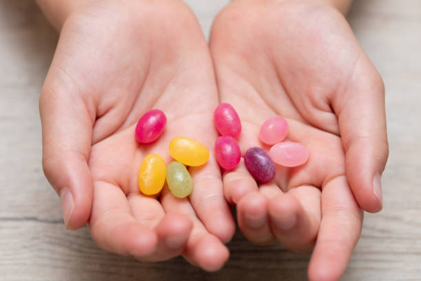 istock Child's hands holding colorful candies 2159174776