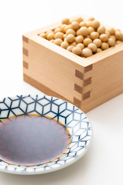 Soy sauce and soybeans on white background