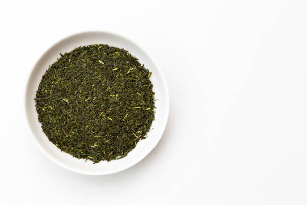 istock Green tea leaves on white background 2159175740