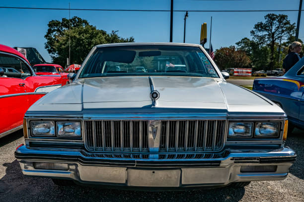 Lanus, Argentina - Sept 24, 2022: Old blue shiny sport 1969 Pontiac GTO two door convertible in a park. Front view. Nature, trees. Classic luxury muscle racing car.
