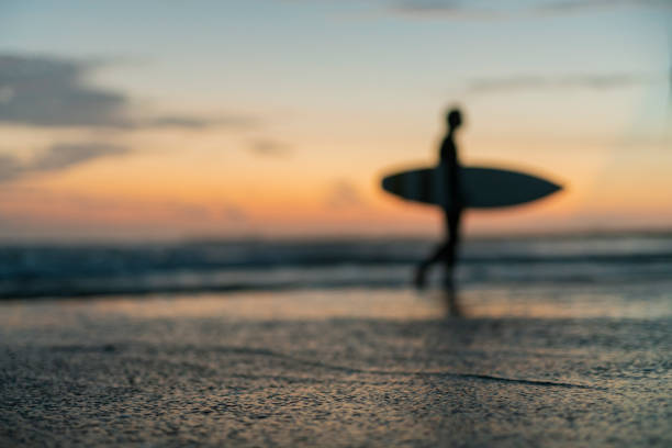 Men surfing at dawn.Man surfing in the morning ocean.