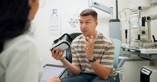 istock Patient, optometry and talking for eye care, advice and consultation with question for optometrist. Man, discussion and vr goggles for healthcare innovation or assessment with confused, wow and wtf 2159180286