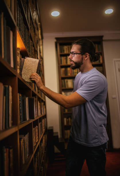 istock a young student is in the library and chooses books 2159182795