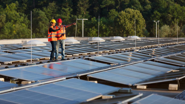 istock Technicians in reflective vests checking solar power plant installed on building roof 2159183125