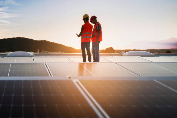 istock Technicians in reflective vests checking solar power plant installed on building roof 2159183153