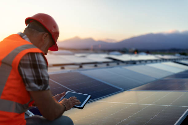 istock Technician using tablet and checking solar power plant installed on building roof 2159183212