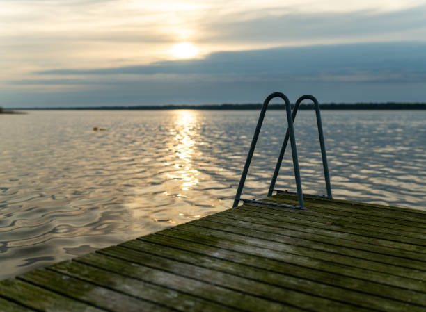 Scenery of a sea stretching to the horizon and a setting sun. Distant view of mountains