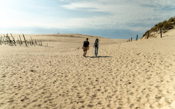 istock People on a beach. Walking in the sand 2159184715