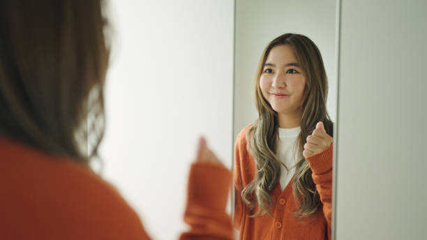 istock Woman looking at herself in the mirror. 2159187661