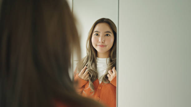 istock Woman looking at herself in the mirror. 2159187663