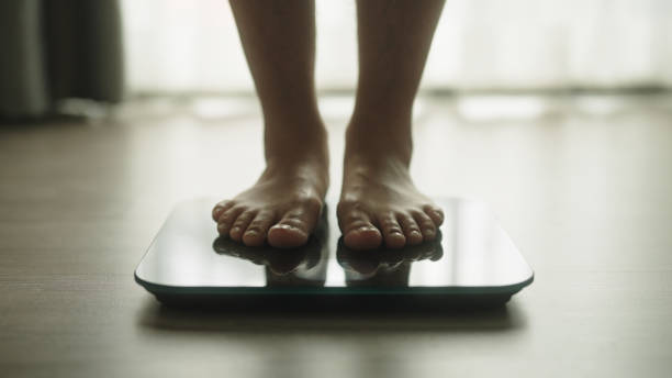istock Foot walking on a body weighing scale. 2159187740