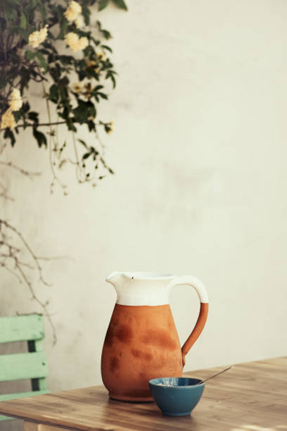 istock Close Up of a White and Terracotta Pitcher on a Rustic Table 2159189518