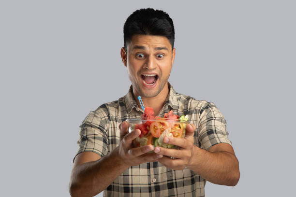 istock Excited young man with salad bowl 2159190037