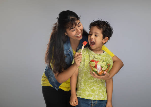 istock Young woman feeding fruit salad to son 2159190067