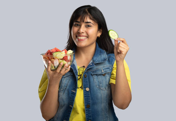 istock Smiling young woman with salad bowl 2159190377