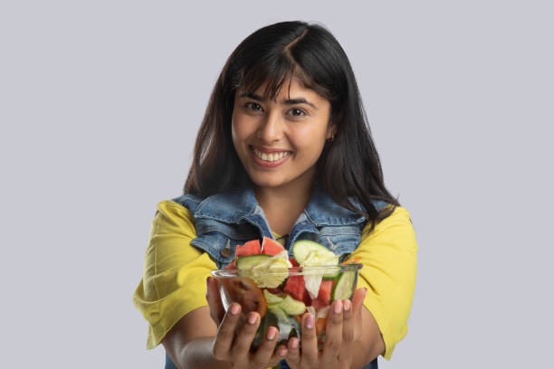 istock Smiling young woman with salad bowl 2159190468