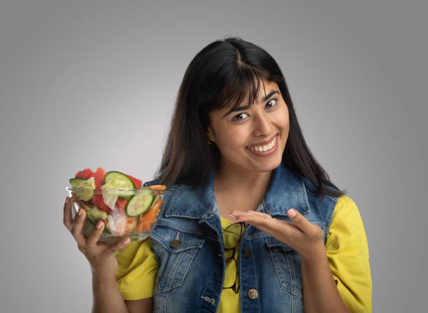 istock Smiling young woman with salad bowl 2159190484