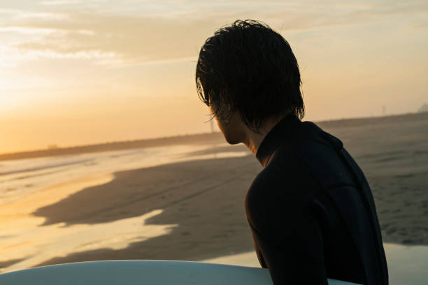 Two women contemplating a horseman on the beach at sunset, Ayamonte, Spain.