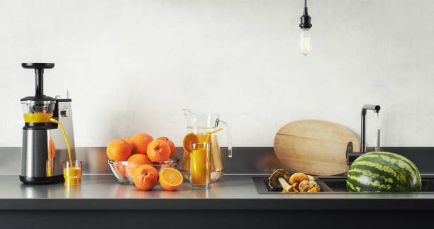 Digitally generated modern domestic kitchen counter featuring a juicer, a bowl of fresh oranges, a glass and pitcher of orange juice, a cutting board, and a watermelon. The scene evokes freshness, health, and a clean eating lifestyle.\n\nThe scene was created in Autodesk® 3ds Max 2025 with V-Ray 6 and rendered with photorealistic shaders and lighting in Chaos® Vantage with some post-production added.