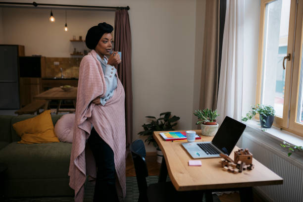 istock Sick woman with common cold standing at home holding hot coffee 2159196283