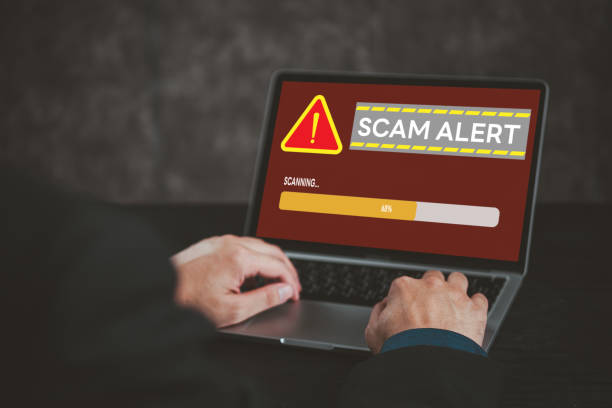 istock Laptop screen displaying scam alert warning. Highlights cybersecurity, online fraud, digital risk awareness. Suitable for tech security, internet safety topics. 2159200344