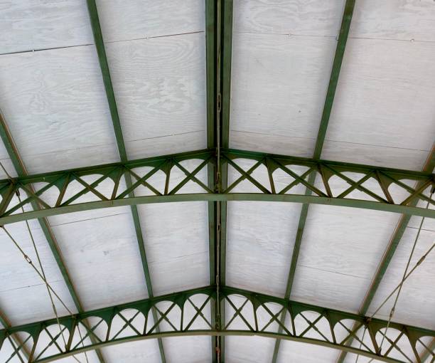 istock Industrial steel roof rafters create a robust and modern framework, showcasing sleek lines and strength. The metallic structure supports the ceiling, providing a stark, functional aesthetic to the space 2159201632