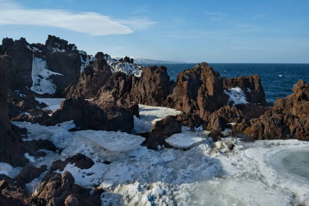 Russia. Far East, Kuril Islands. Very hard and sharp basalt rocks along the coast of the Sea of Okhotsk on the island of Iturup.