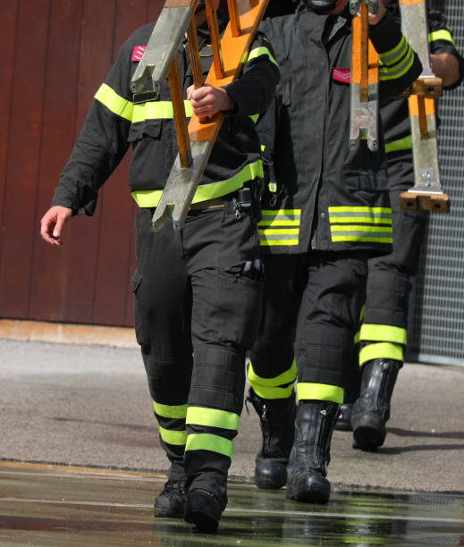 istock Three firefighters walk with a ladder after training at the fire station to extinguish 2159203159