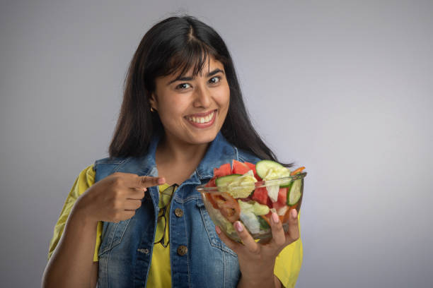 istock Smiling young woman with salad bowl 2159205276