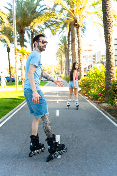 Interracial roller skater couple skating happily on the beach