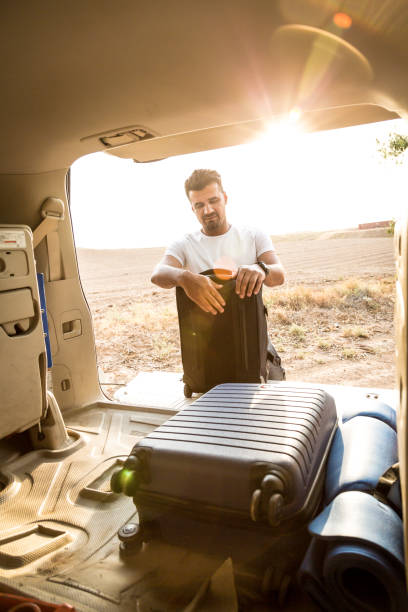 istock A man is packing luggage in a car trunk 2159212847