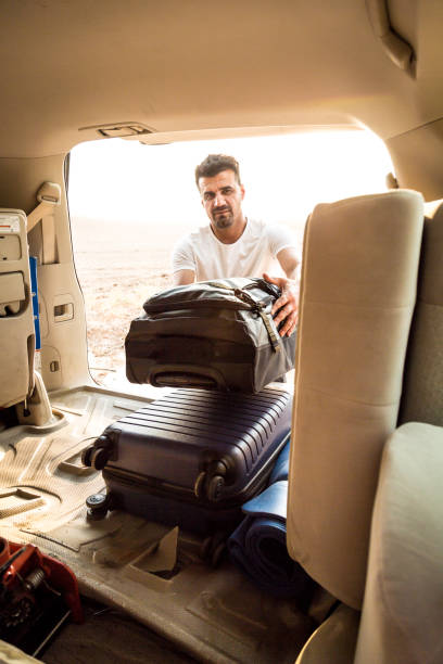 istock A man is packing luggage in a car trunk 2159212897