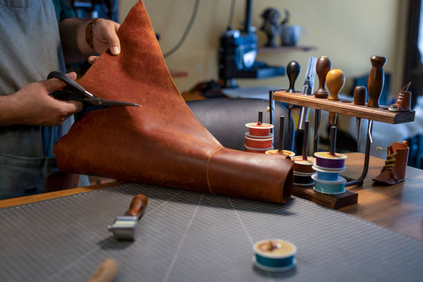 Scissors make an incision in a piece of genuine leather