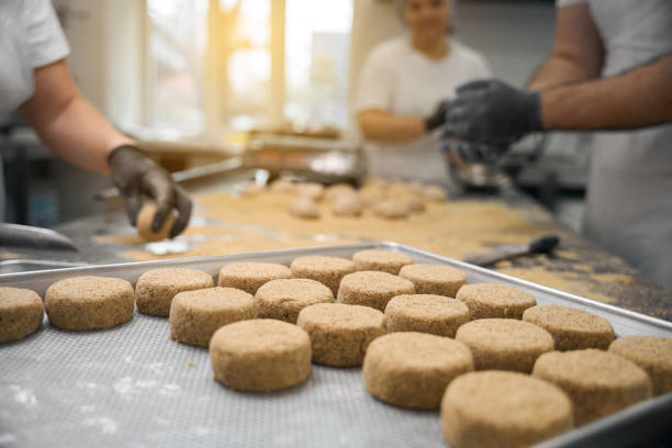istock Team of kitchen workers forms cutlets on large wooden table 2159223035