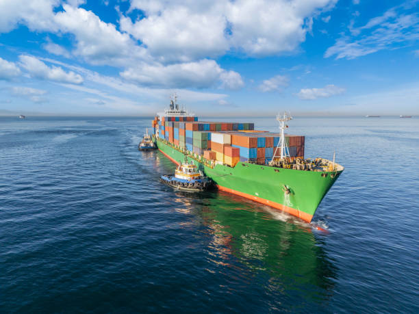 istock Aerial view of Cargo container ship carrying container and running with tugboat for import goods to cargo container terminal for customs. Concept of logistics transportation and shipping. 2159224562